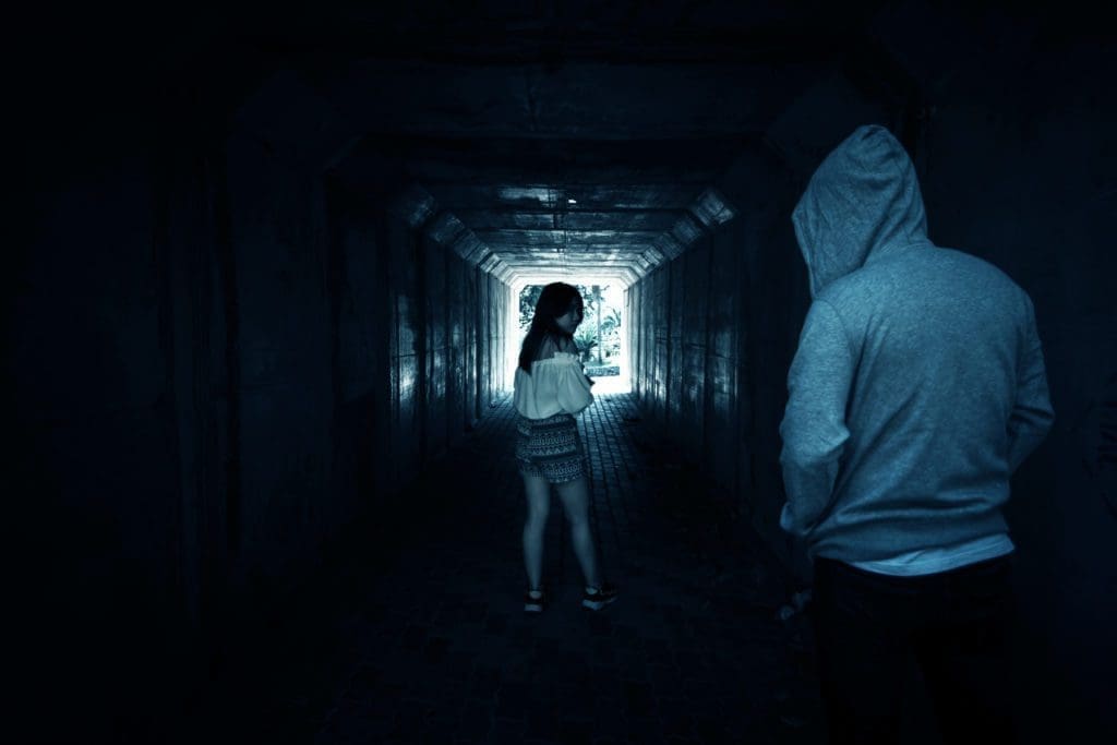 A man following a woman in a tunnel