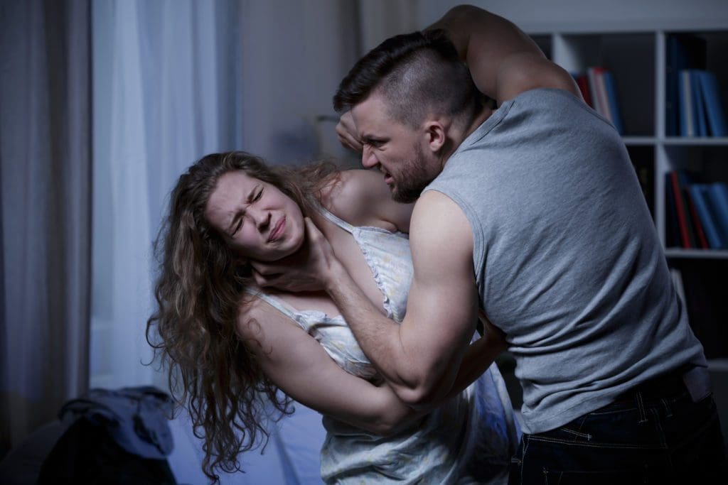 A man grabs his wife by the neck, committing a strangulation and suffocation against her.