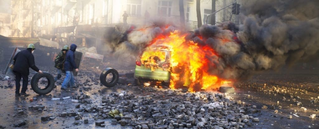 A car burns during a riot