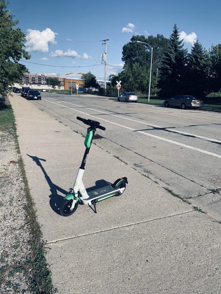 An electric scooter rests on a Milwaukee sidewalk.